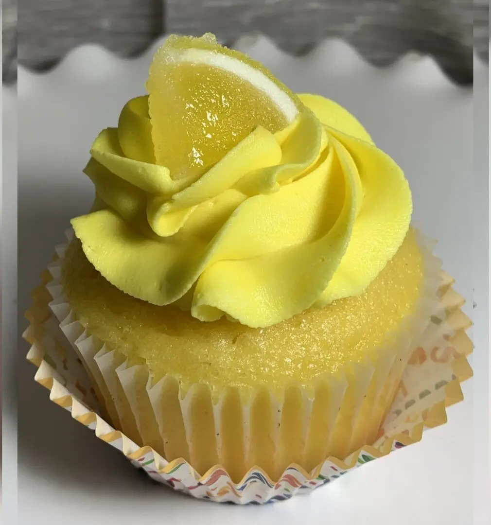 A cupcake with lemon and yellow frosting on top.